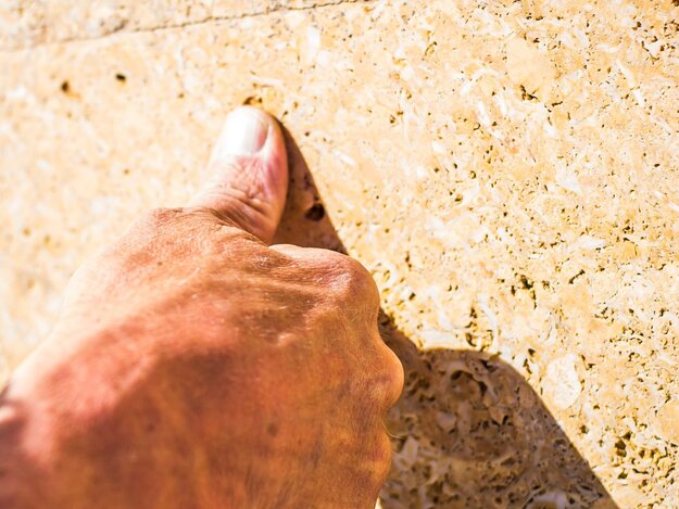 finger-auf-natursteinoberflache-aestivate | aestivate Fingerspitze auf Kalksteinoberfläche aestivate